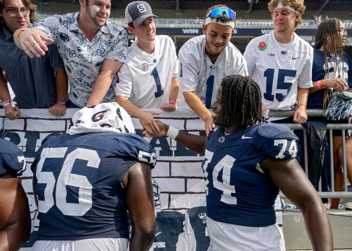 Penn State’s Olumuyiwa Fashanu greets Penn State students that made a banner for he fellow offensive lineman during the game on Saturday, Sept. 9, 2023.
