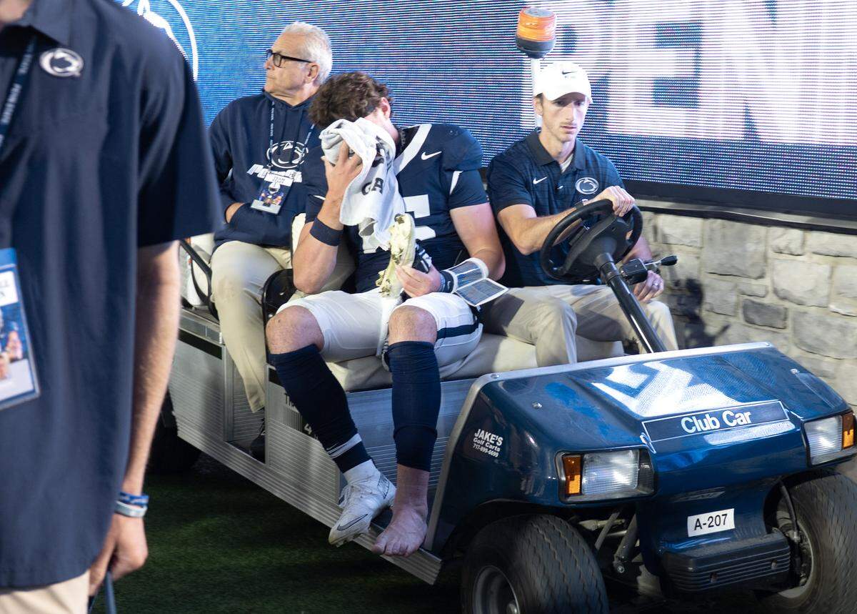Penn State quarterback Drew Allar covers his face as he is carted off teh field during the game against Northwestern on Saturday, Oct. 11, 2025.