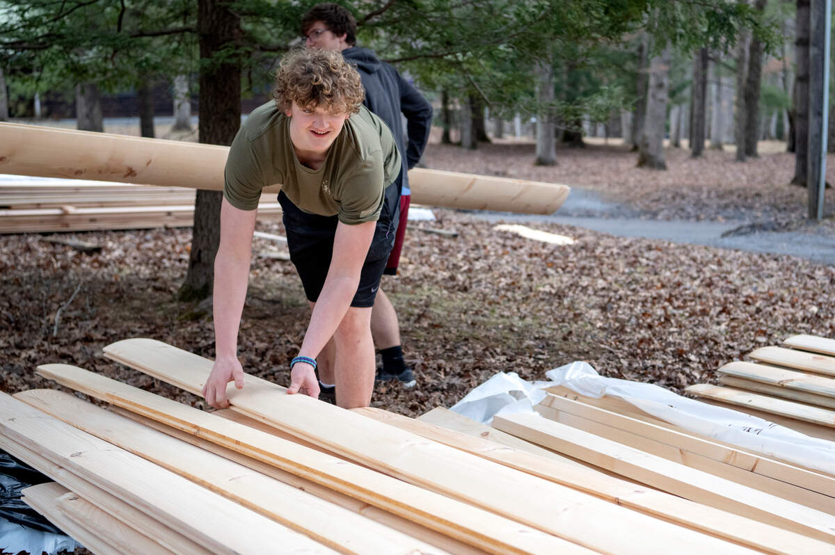 Will English and fellow members of Scout Troop 32 work together on March 19 to prepare the wood for the siding of the new David O’Connell Health Education Building at Seven Mountains Scout Camp on Saturday.
