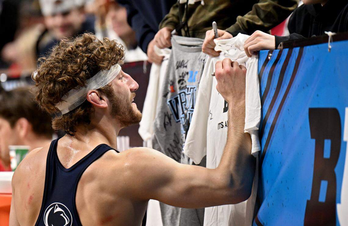Penn State's Mitchell Mesenbrink signs shirts for young fans after winning the 165-pound championship at the Big Ten wrestling championships on Sunday, March 8, 2026.