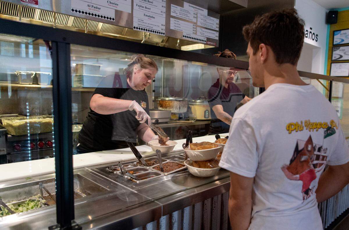 A customer gets a Mexican bowl at El Jefe’s Taqueria on Wednesday.