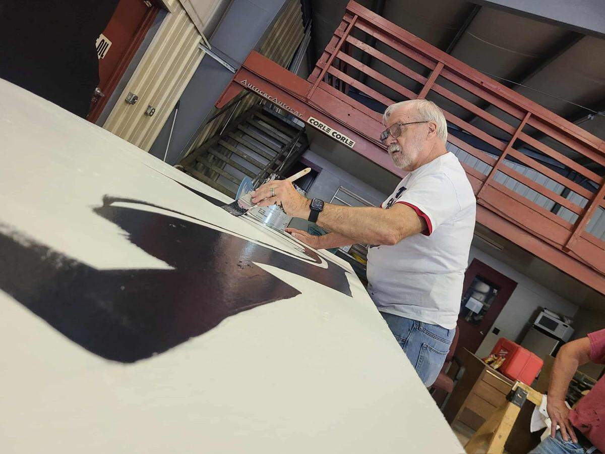 John Herrington paints a wooden panel of the newly-rebuilt Philipsburg Santa Claus display.
