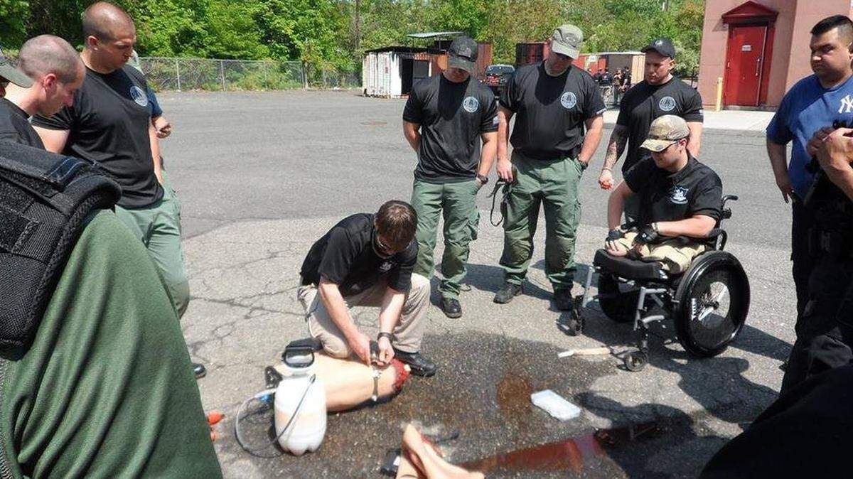 Adam Hartswick, at right in a wheelchair, teaches a Tactical Combat Casualty Care course for EMTs and firefighters in New Jersey.
