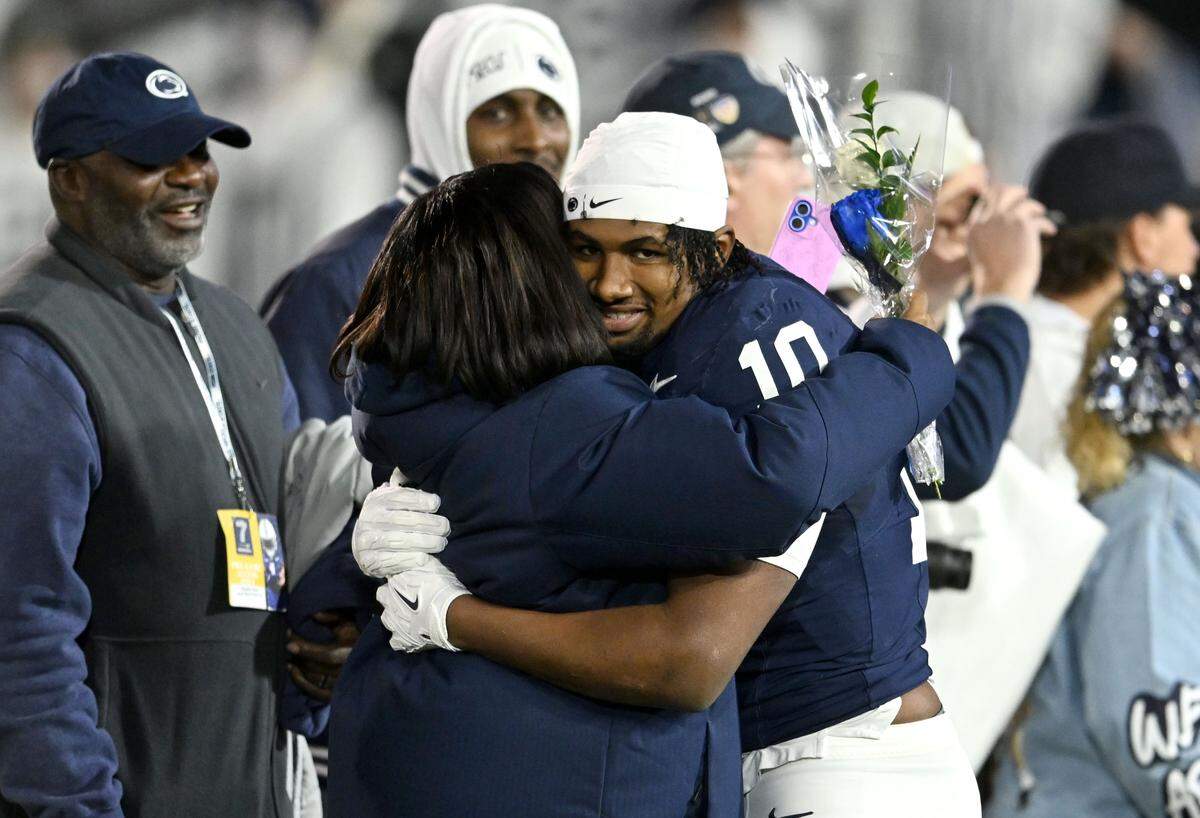 Penn State running back Nick Singleton hugs his family during the senior day celebration before teh game against Nebraska on Saturday, Nov. 22, 2025 at Beaver Stadium.