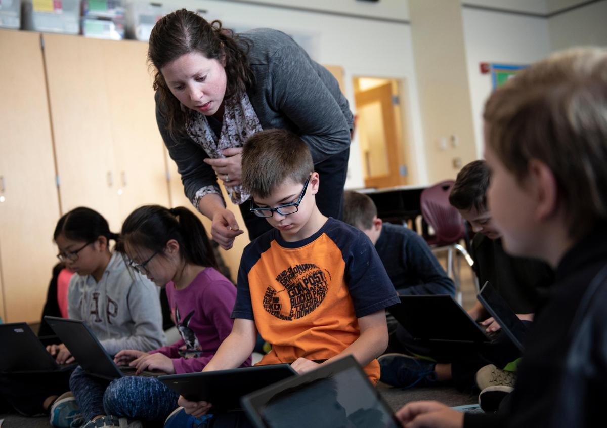 Tara Pollick helps her student, Caleb Kraft, think about a question showing in the laptop in the STEM class on Oct. 17, 2018, at Ferguson Township Elementary School in State College, Pa. Pollick, a STEM teacher at Ferguson Township Elementary School, said she liked helping her students approach solutions. (Photo/Baidi Wang)
