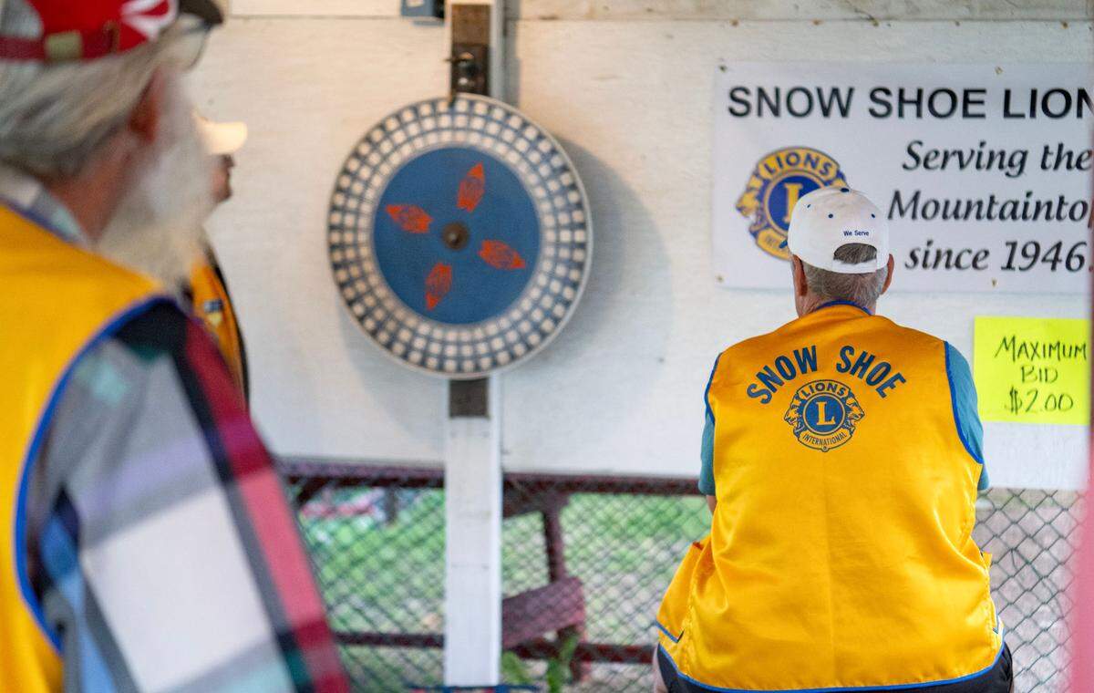 Snow Shoe Lions Club members watch the wheel spin for a round of chuck-a-luck at the Snow Shoe Carnival on Tuesday, June 18, 2024.