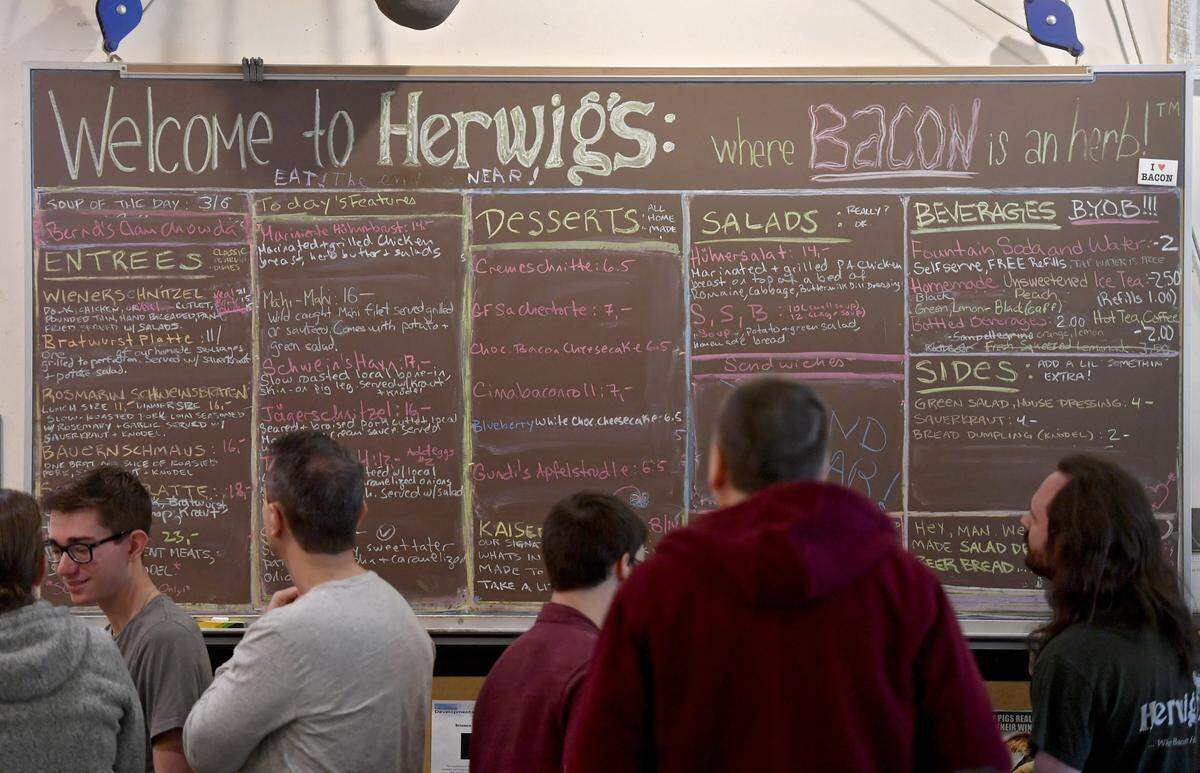 Diners read the chalkboard menu at Herwig’s Austrian Bistro on Saturday.
