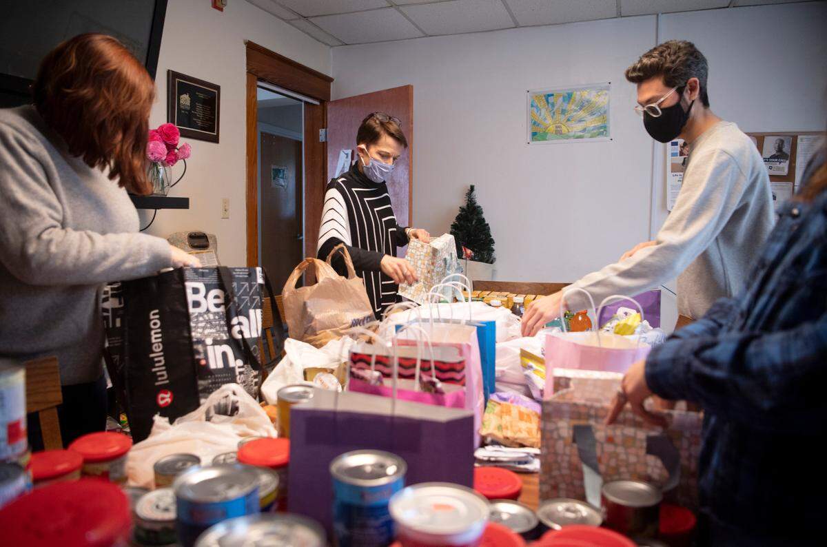 Staffers of Centre House Shannon Nash, Mary Daniloff, Tyler Wolfe and Catie Harpster package donated food into bags for the clients of the shelter on Monday, Feb. 14, 2022.