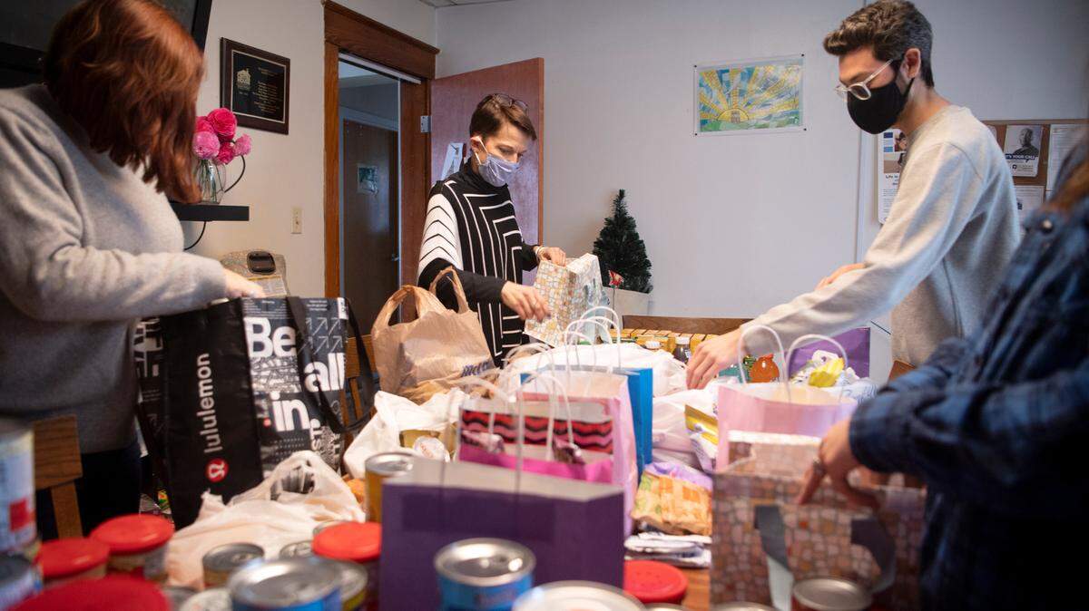 Staffers of CentreHouse Shannon Nash, Mary Daniloff, Tyler Wolfe and Catie Harpster package donated food into bags for the clients of the shelter on Monday, Feb. 14, 2022.