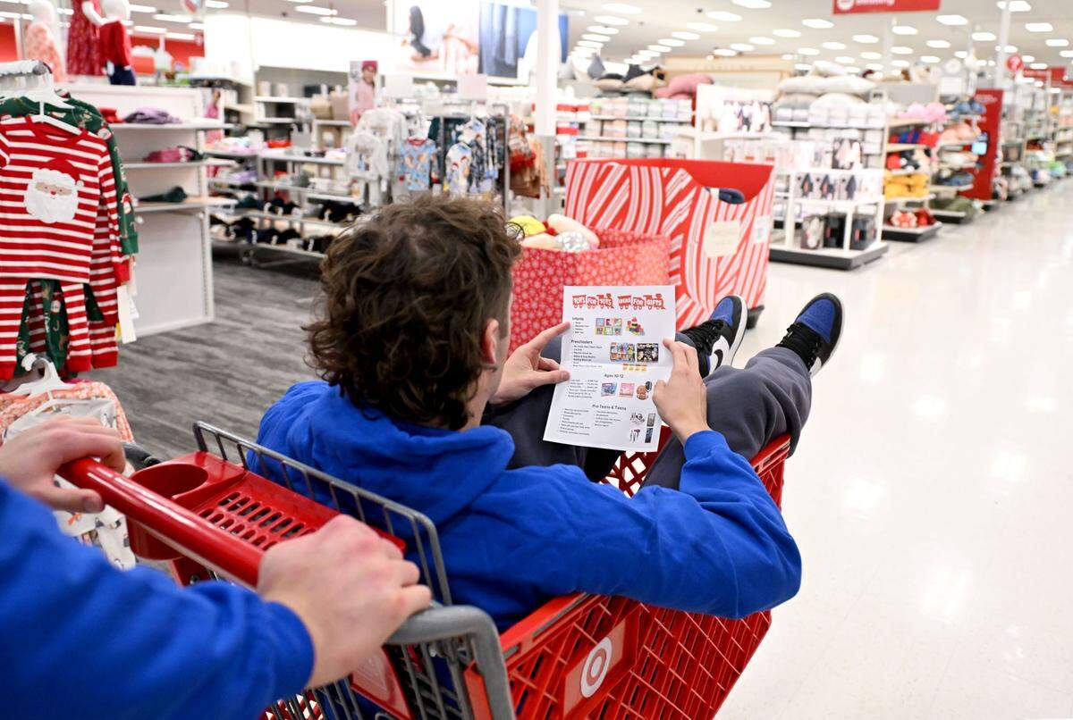 Ryan Barker browses a toy suggestion list as he and Penn State football teammates go on a shopping spree at Target in State College for Toys for Tots on Monday, Dec. 2, 2024.