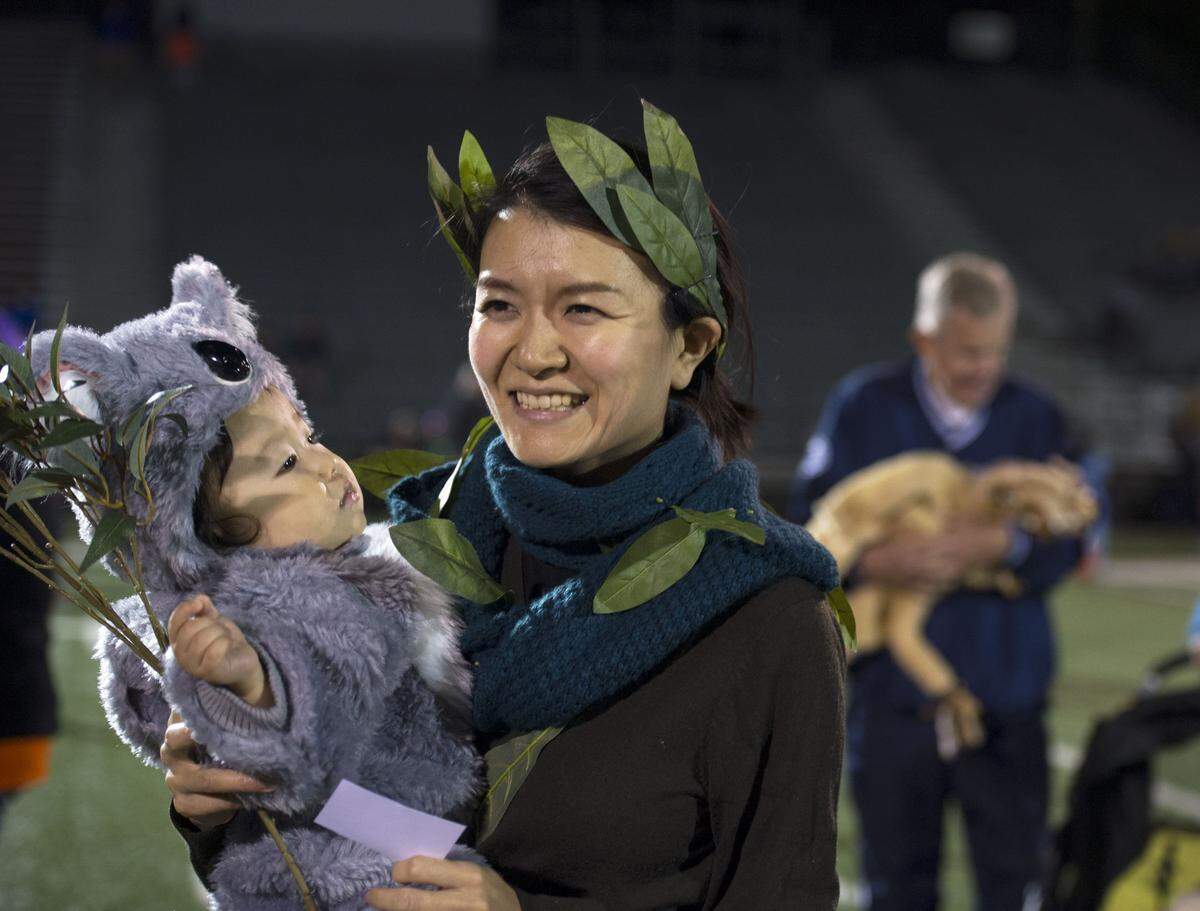 Rieko Tsusaka holds Jin Kim during the CRPR Halloween Costume Parade in 2016 at Memorial Field.