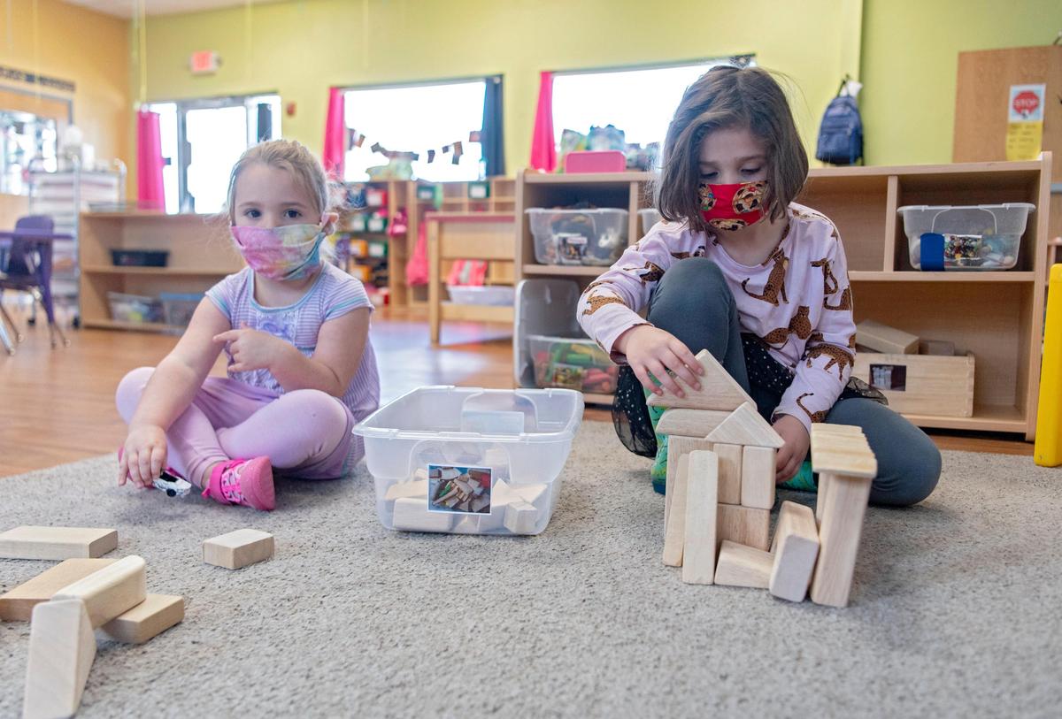 Taylor Burns, 3, and Abby Phillips, 5, wear their masks as they build towers at Step By Step School for Early Learning on Tuesday, May 12, 2020.