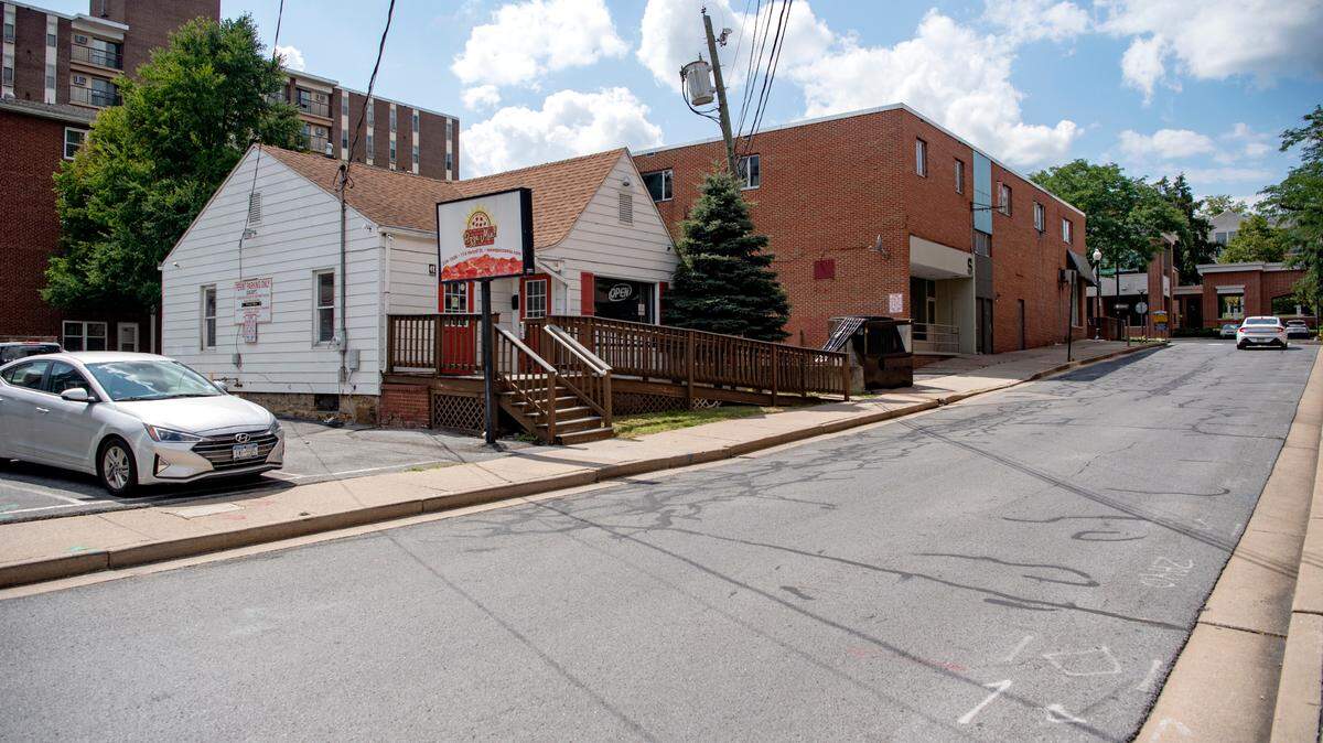Traffic passes on Hetzel Street in downtown State College on Tuesday. The southbound lane of Hetzel Street will be closed for two years starting in December while a 12-story mixed-use building is built. Several existing buildings, including the Pizza Mia, will be demolished.