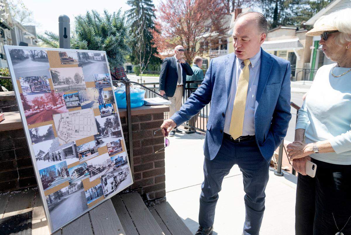 State Rep. Kerry Benninghoff looks at historic photos of Lemont with residents during the Pike Street traffic calming and streetscape dedication on Friday, April 21, 2023.