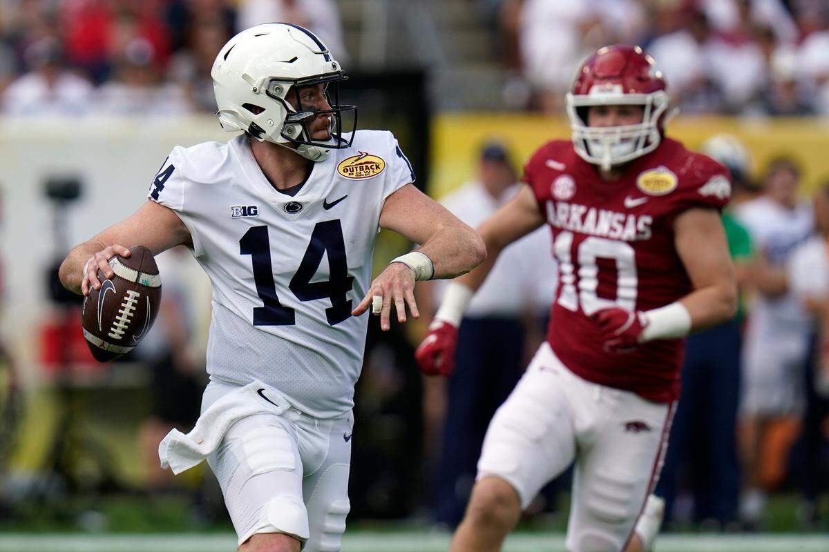 Penn State quarterback Sean Clifford (14) throws a pass as he is pressured by Arkansas linebacker Bumper Pool during the first half of the Outback Bowl NCAA college football game Saturday, Jan. 1, 2022, in Tampa, Fla.