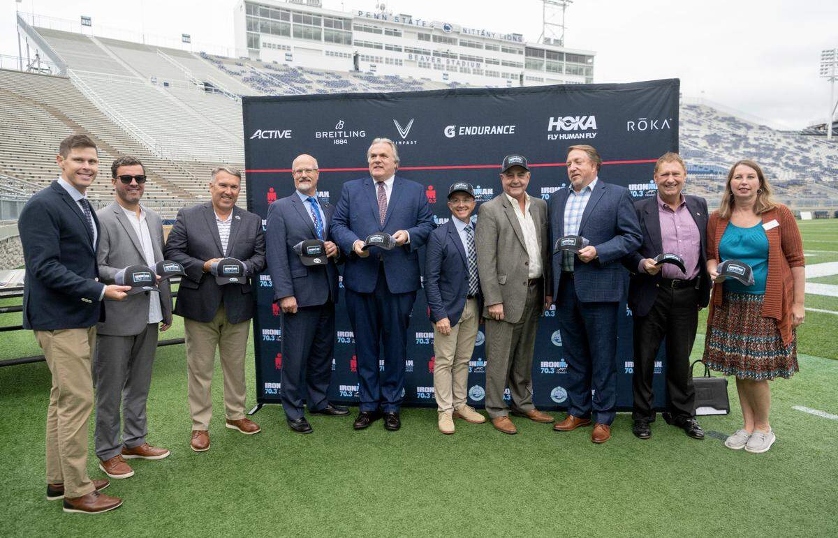 Members from the Happy Valley Adventure Bureau and the Ironman Group gather for a photo after announcing the Ironman 70.3 Happy Valley Triathlon on Thursday at Beaver Stadium.