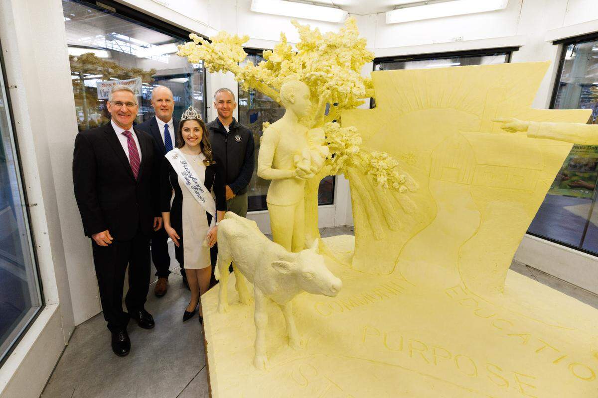 Agriculture Secretary Russell C. Redding, ADANE CEO John Chrisman, Pennsylvania Dairy Princess Selina Horst, Lancaster County Dairy Farmer Steve Harnish stand with the butter sculpture for the 2023 Pennsylania Farm Show.