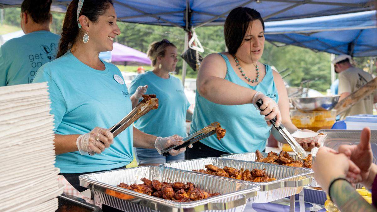 Juniper Village’s Liz Plozner-Chalfa laughs as she gets wings ready for an order during the finals for WingFest at Tussey Mountain on Thursday, Aug. 4, 2022.