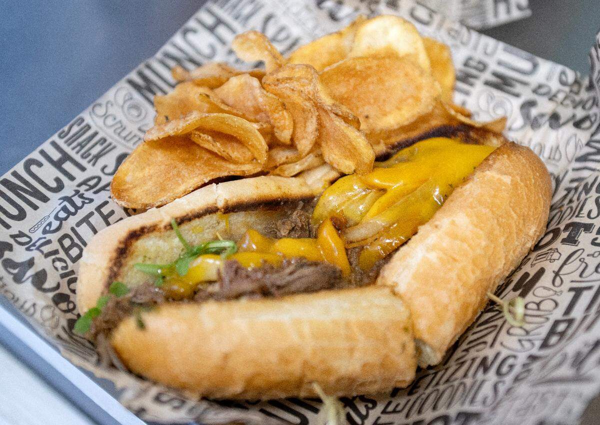 A chimichurri cheesesteak featuring braised beef, chimichurri sauce, sharp cheddar, arugula, sautéed onions and peppers on a garlic butter toasted roll, served with house made chips from Dubbs Grub on Friday, Jan. 17, 2025 at Boal City Brewing.