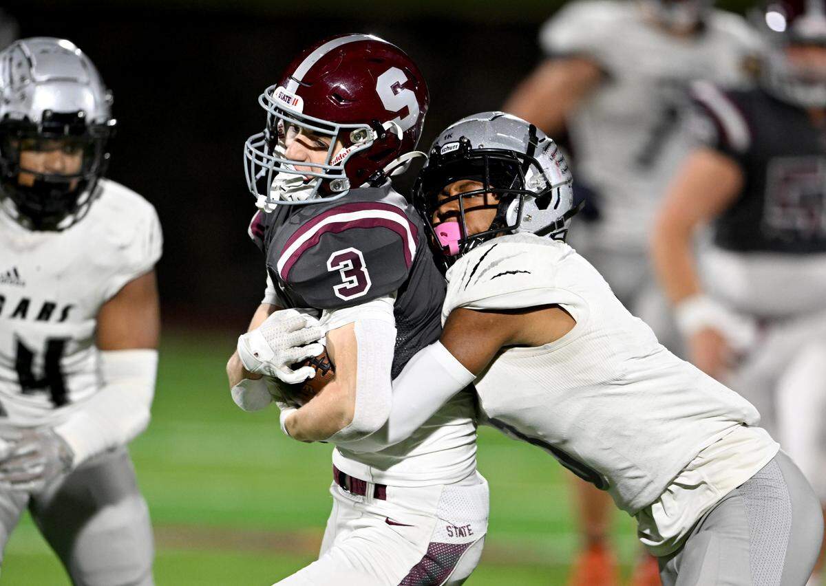 A Harrisburg defender tires to stop State College Ty Salazer as makes a catch and runs with the ball during the game on Friday, Oct. 13, 2023.