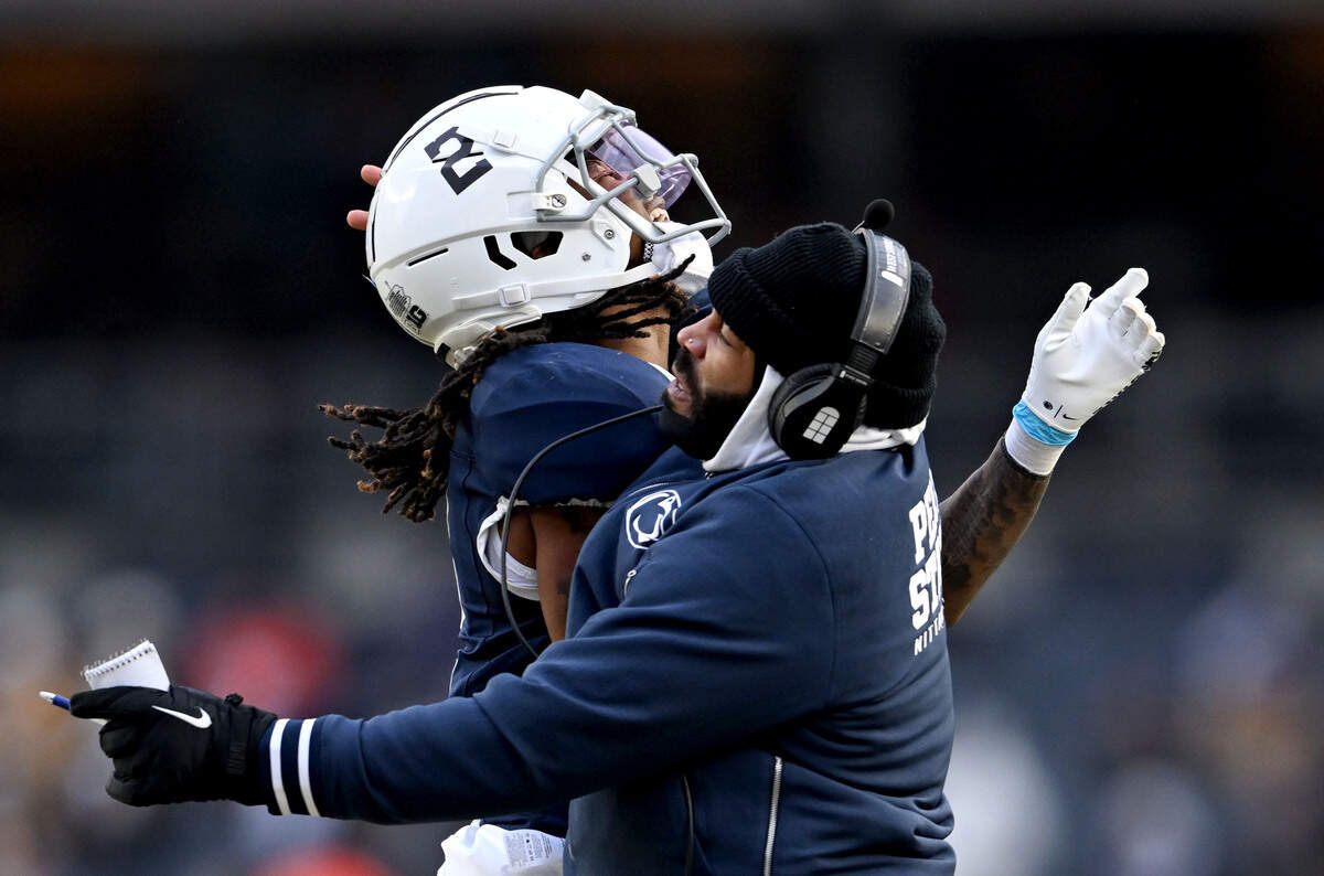 Penn State cornerback Audavion Collins celebrates a play with coach Jordan Lucas during the Pinstripe Bowl against Clemson at Yankee Stadium on Saturday, Dec. 27, 2025.
