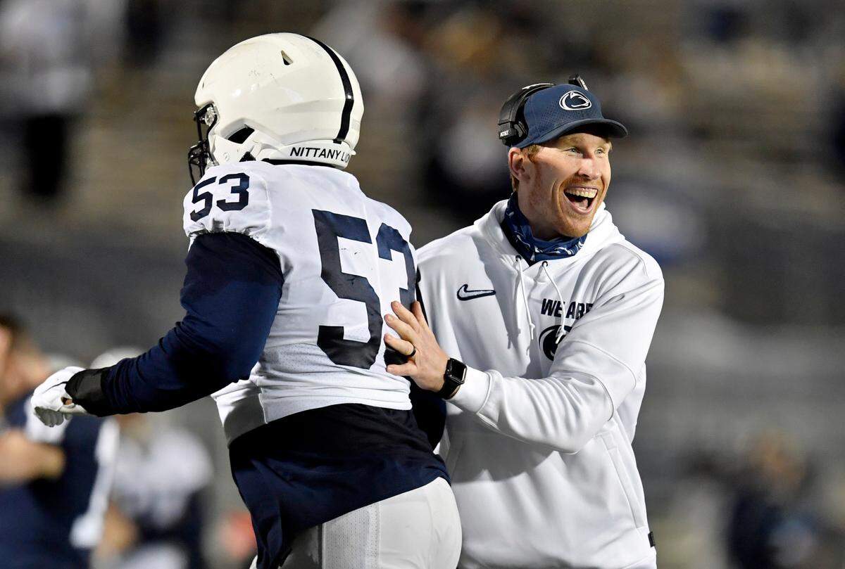 Penn State offensive line coach Phil Trautwein congratulates Rasheed Walker as he comes off the field after a touchdown during Penn State football practice on Friday, April 23, 2021 at Beaver Stadium.