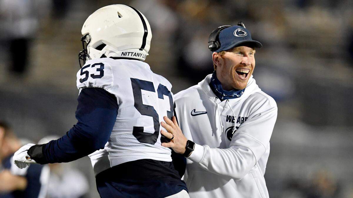 Penn State offensive line coach Phil Trautwein congratulates Rasheed Walker as he comes off the field after a touchdown during Penn State football practice on Friday, April 23, 2021 at Beaver Stadium.
