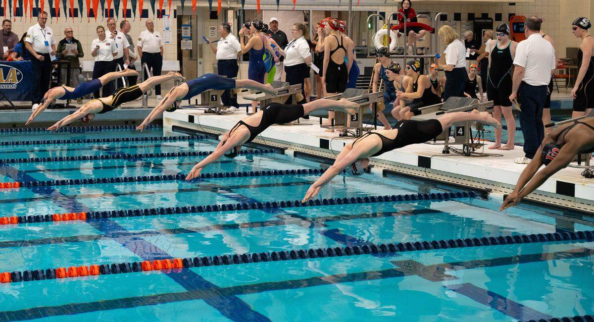 State College's Isla Reite, third from the right, dives into the pool to lead off the 400 freestyle relay during the PIAA Class 3A Swimming & Diving Championships at Kinney Natatorium in Lewisburg, Pa., Thursday, March 12, 2026. State College won with a time of 3:24.98.