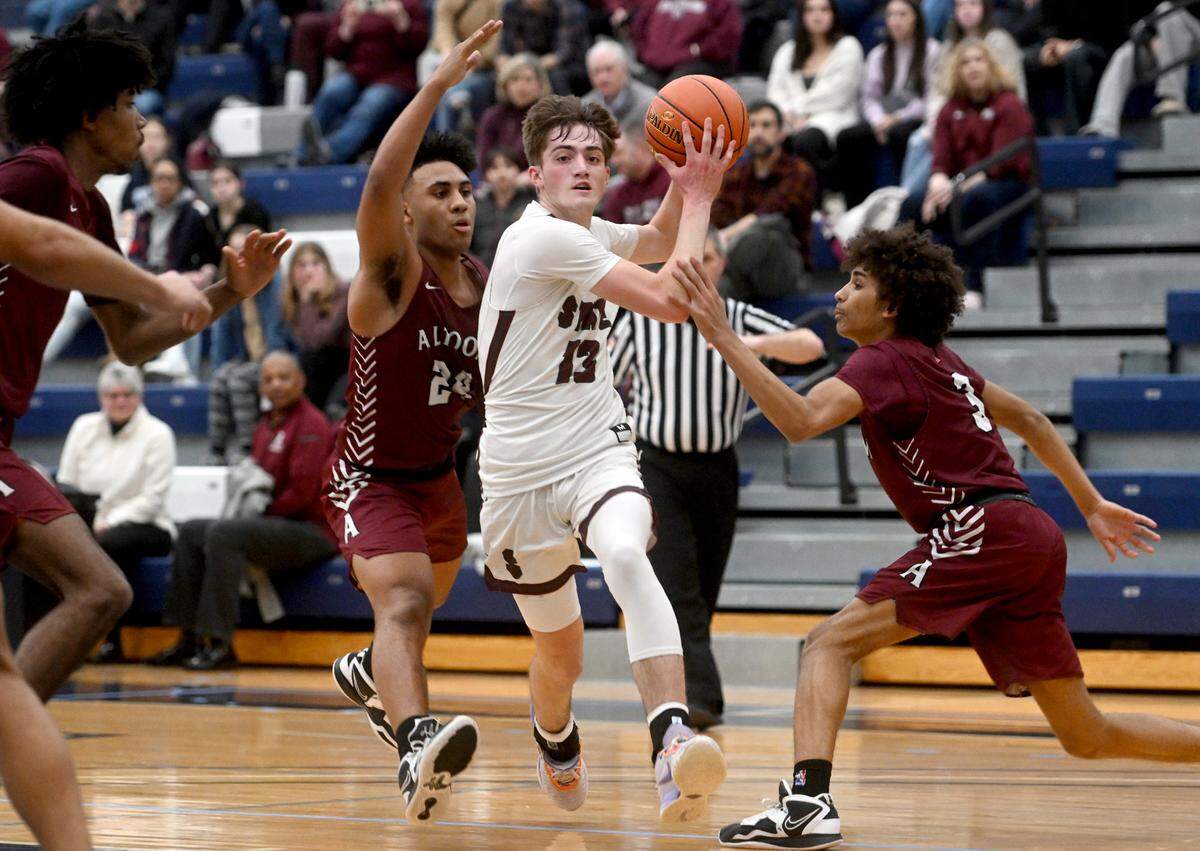 State College’s Ryan Perks dribbles around Altoona defenders during the District 6 6A championship game at Mount Aloysius College on Friday, Feb. 24, 2023.