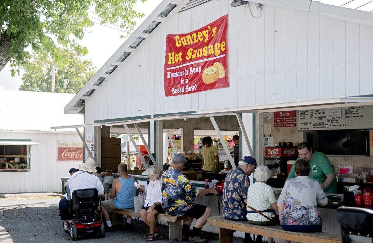 Fair goers enjoy lunch from Gunzey’s hot sausage at the Centre County Grange Fair on Friday, Aug. 15, 2025. The homemade soup in a bread bowl is a fair favorite.