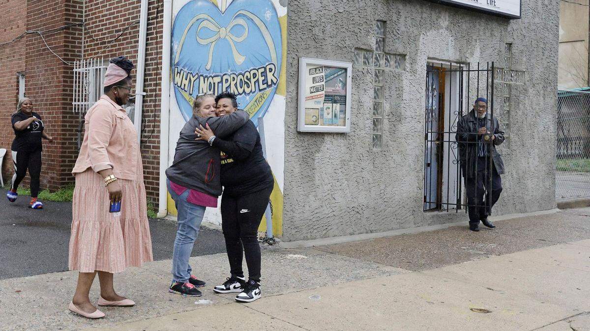Penny Martin, left, and the Rev. Michelle Simmons, founder and executive director of Why Not Prosper, hug outside of a recovery home in Philadelphia. Simmons said the new licensing system will “make owners … step up their game.”