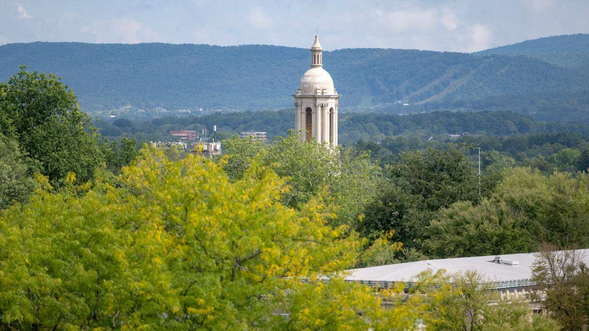 The bell tower of Old Main sticks out above the trees on the Penn State campus on Monday, Sept. 12, 2022.  