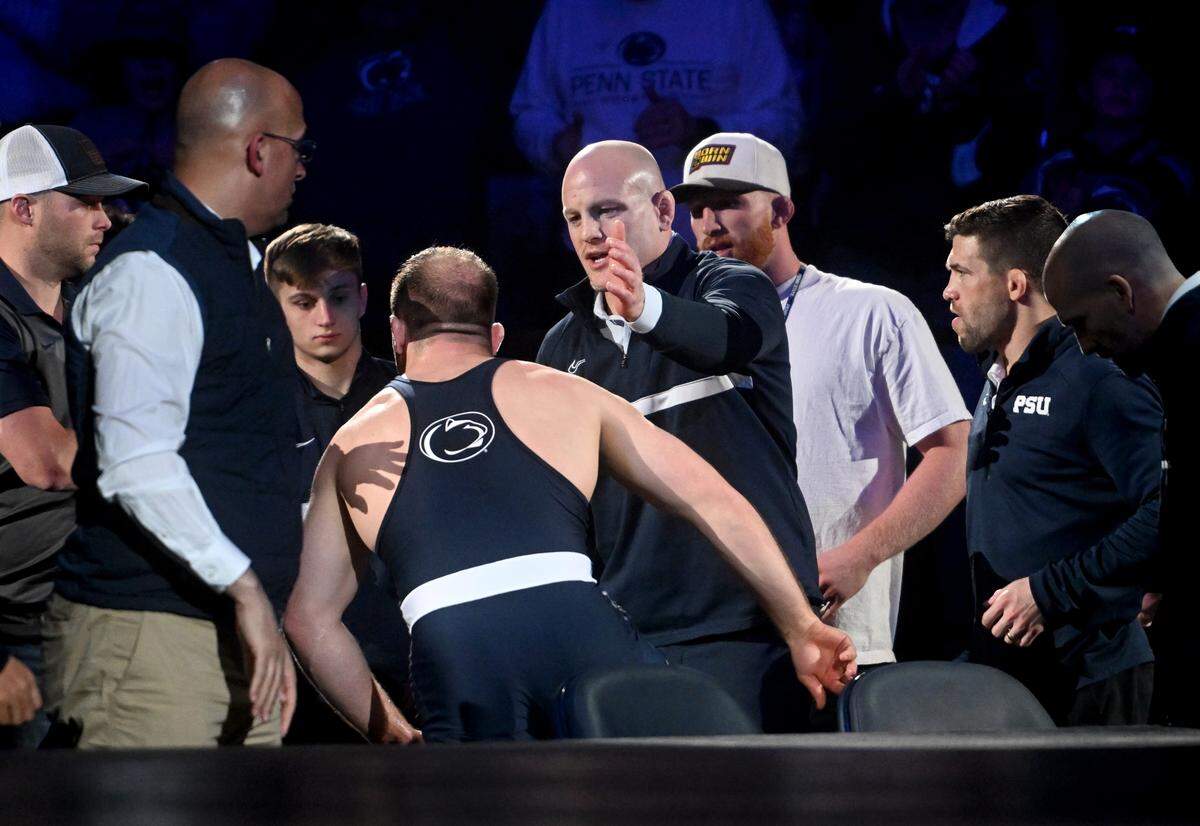 Penn State wrestling coach Cael Sanderson congratulates Max Dean as he comes off the mat from his win against Iowa’s Jacob Warner during the match on Friday, Jan. 27, 2023.