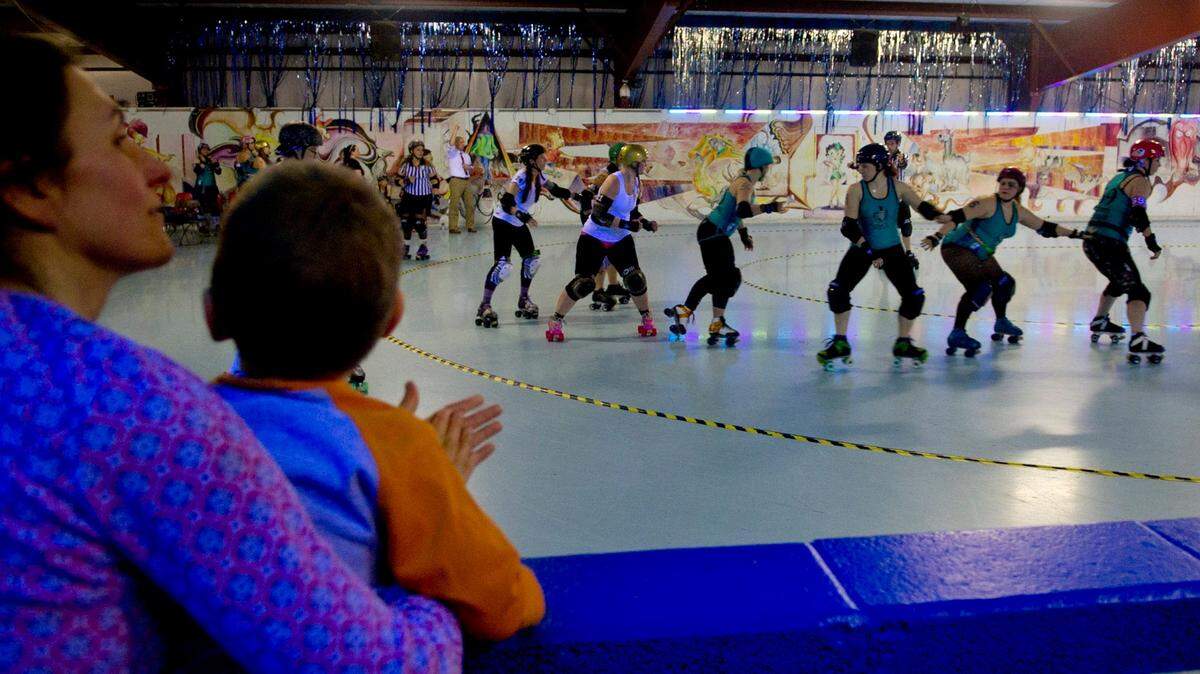 Fans cheer on the Happy Valley Dolls’ and the Iron Mountain Rollergirls during the “Queens of the Mountain” roller derby bout at Penn Skates in 2014.