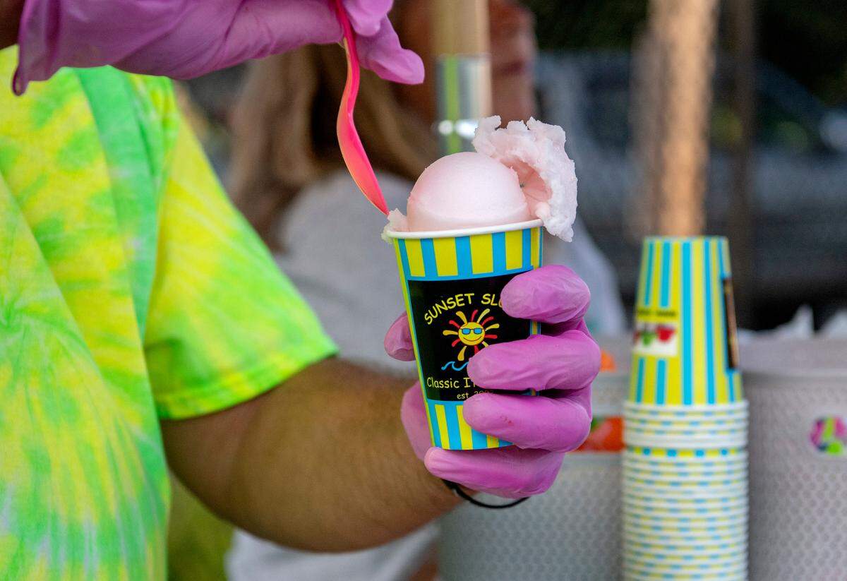 A cup of ruby red grapefruit Italian ice from Sunset Slush Happy Valley is prepared for a customer at Welch Pool on Wednesday.
