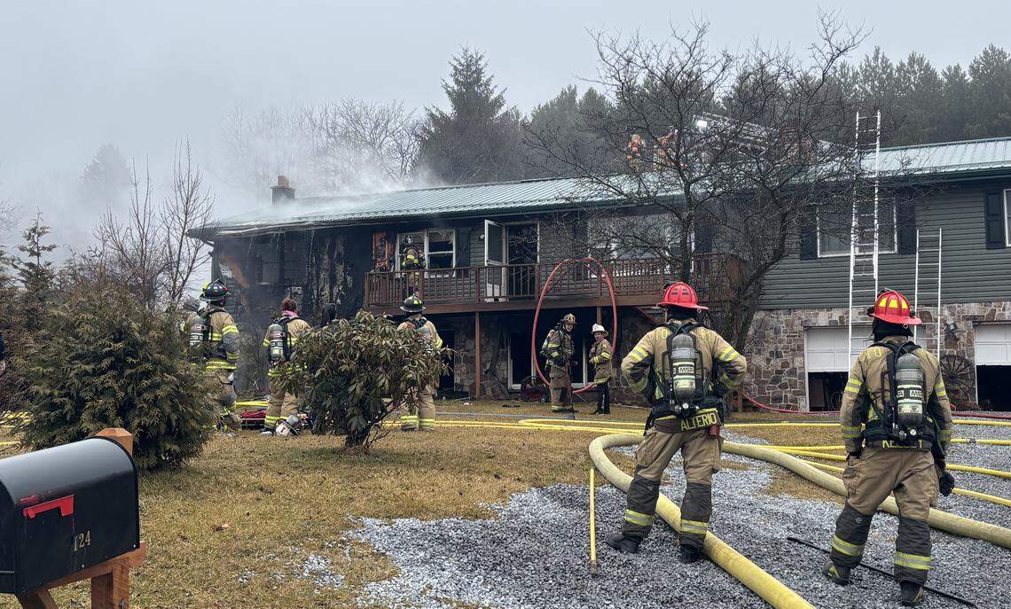 Firefighters look on Saturday, March 7, 2026, after battling a two-alarm house fire in the 100 block of Greens Valley Road near Centre Hall.