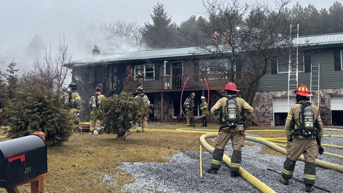 Firefighters look on Saturday, March 7, 2026, after battling a two-alarm house fire in the 100 block of Greens Valley Road between Centre Hall and Pleasant Gap.