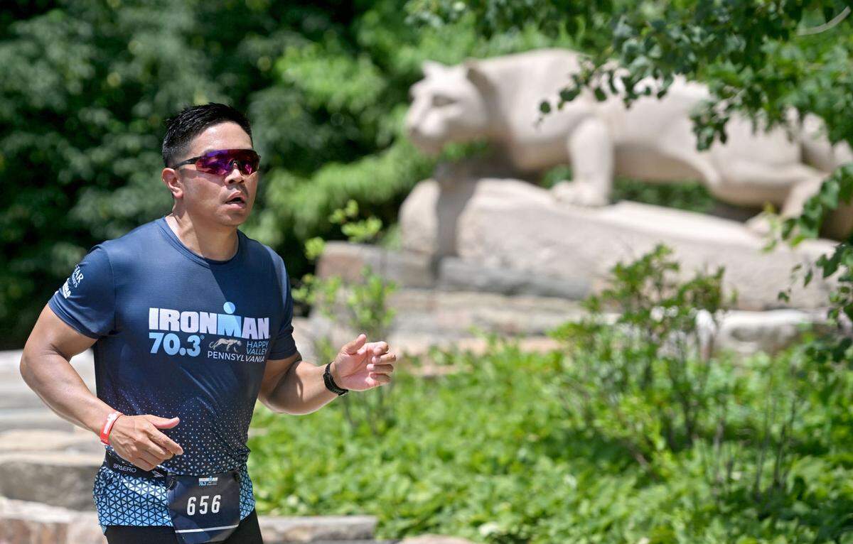 Athletes pass the Nittany Lion shrine during the 13.1 mile run for the Ironman 70.3 Pennsylvania Happy Valley on Sunday, June 30, 2024.