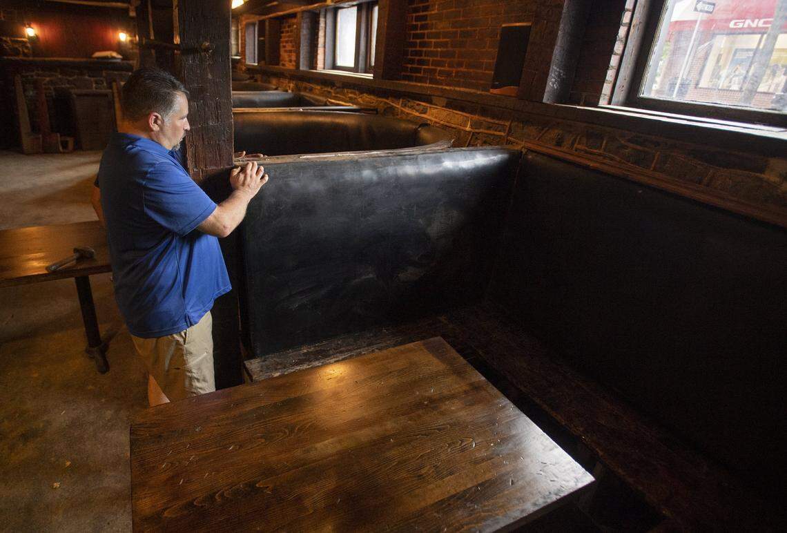 Tom Trosko works to reinstall booths in Doggie's Rathskeller and Garden before opening for a preview during Arts Fest weekend.