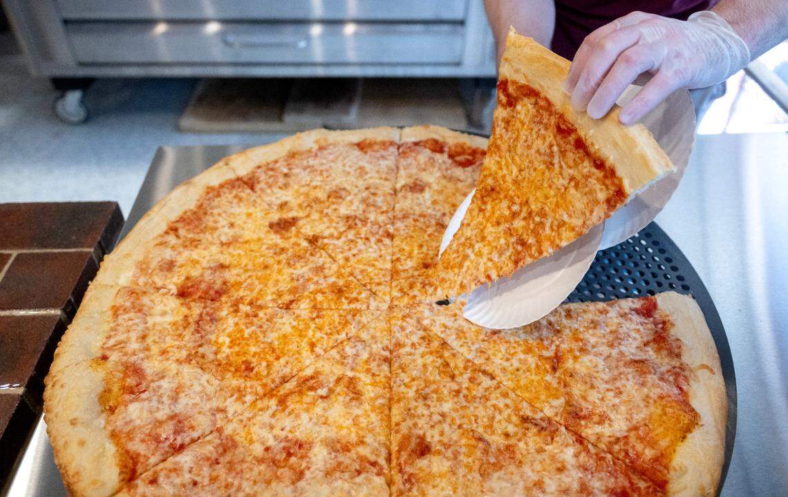 Colin Farrell serves a slice of cheese pizza from a 28-inch pie at Benny Leone’s on Wednesday, June 4, 2025.