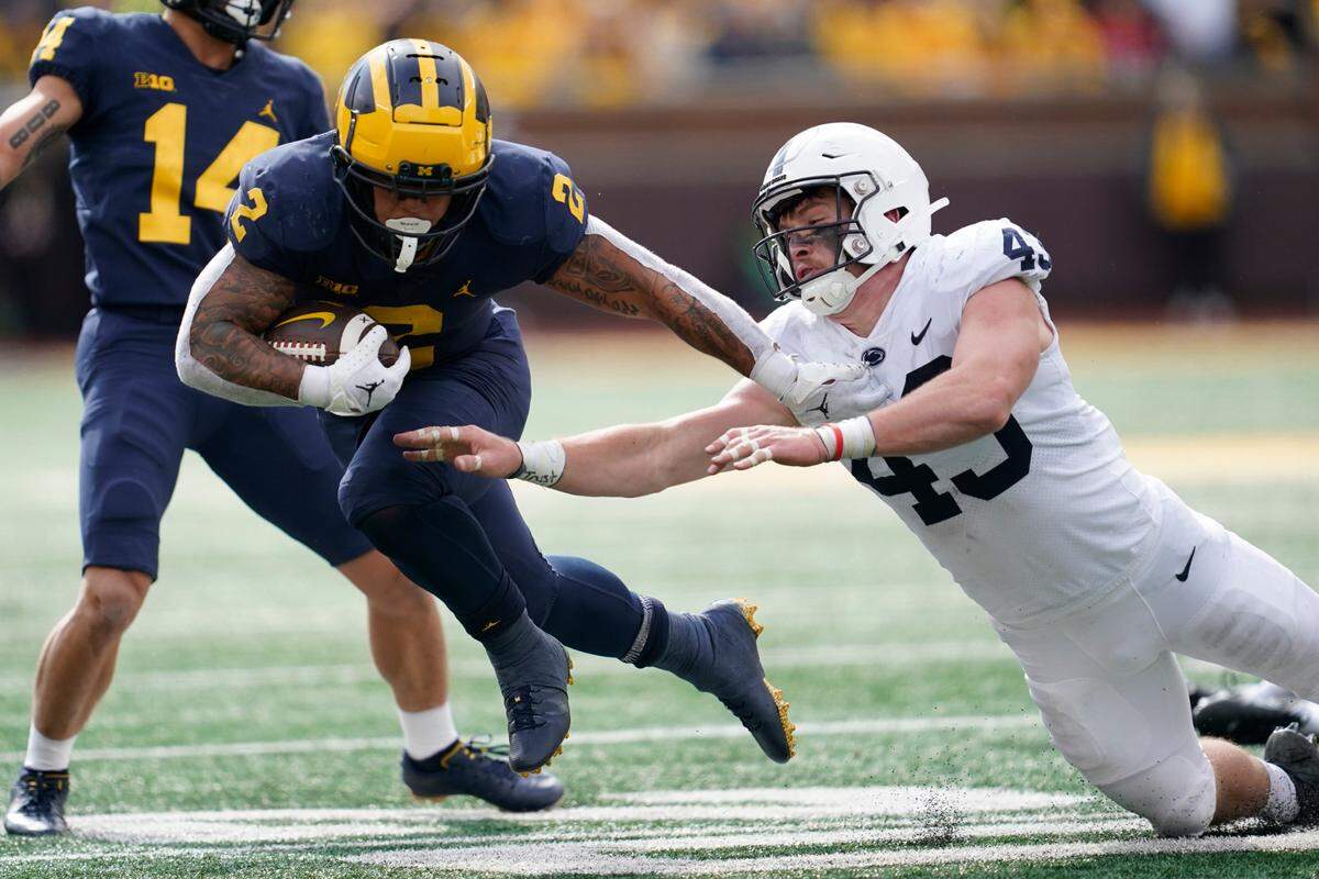 Michigan running back Blake Corum (2) bounces off the tackle of Penn State linebacker Tyler Elsdon (43) in the first half of an NCAA college football game in Ann Arbor, Mich., Saturday, Oct. 15, 2022.