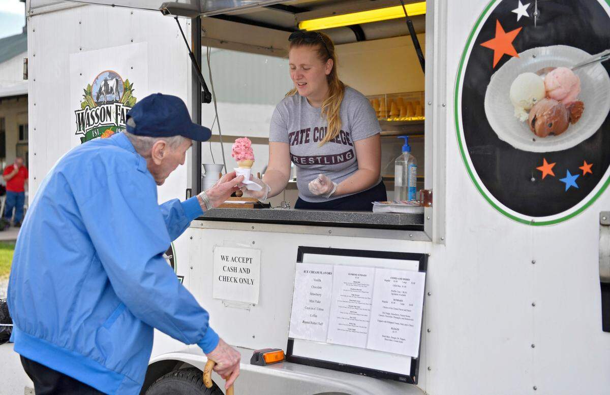 Nicole Wasson serves a cone of strawberry ice cream Thursday at the Wason Farm Market ice cream trailer.