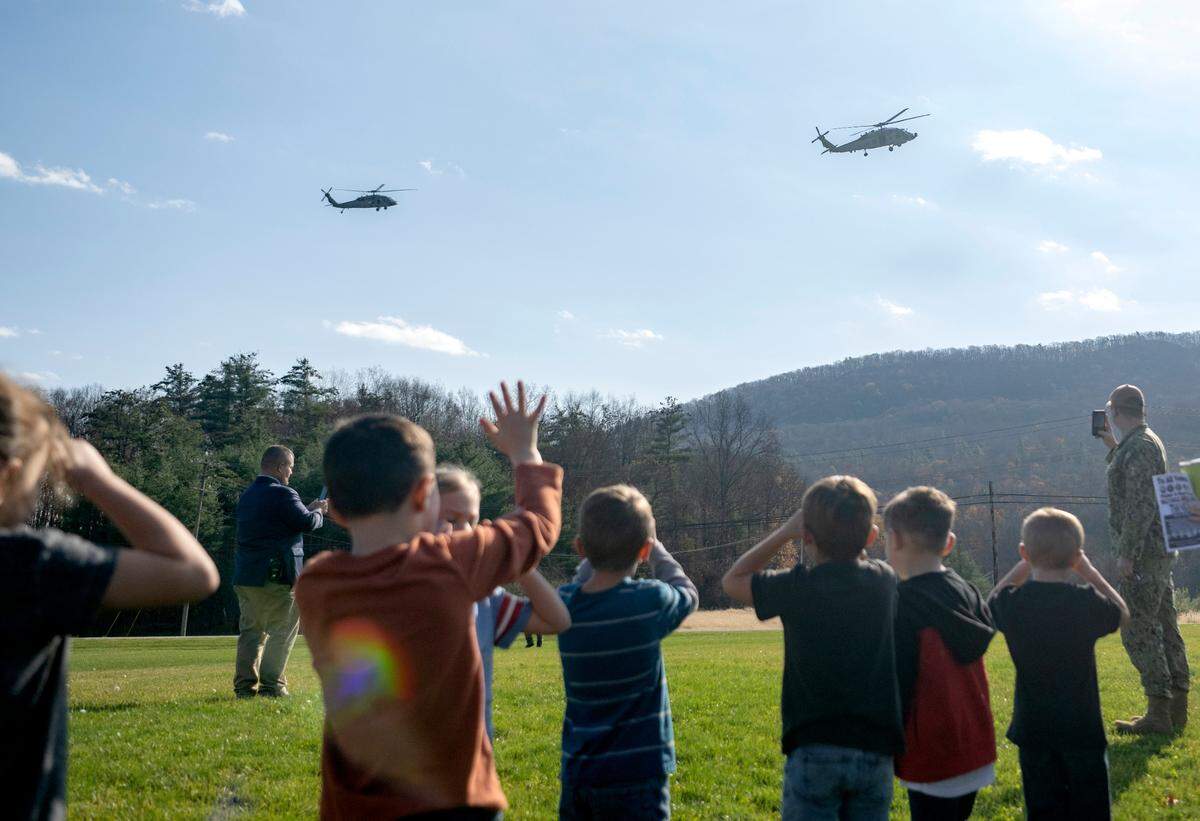 Bald Eagle Area students wave to the two Navy helicopters as they land at the school as part of the Veterans Day celebration on Thursday, Nov. 9, 2023.
