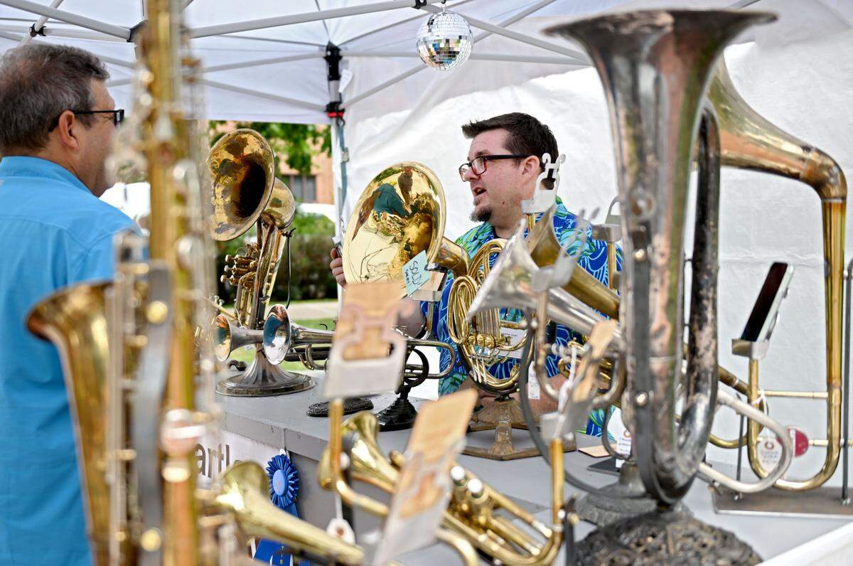Christopher Locke takes about the musical instruments that he’s transformed into speakers at his booth along Pollock Rd. at the Central Pennsylvania Festival of the Arts on Thursday, July 11, 2024.