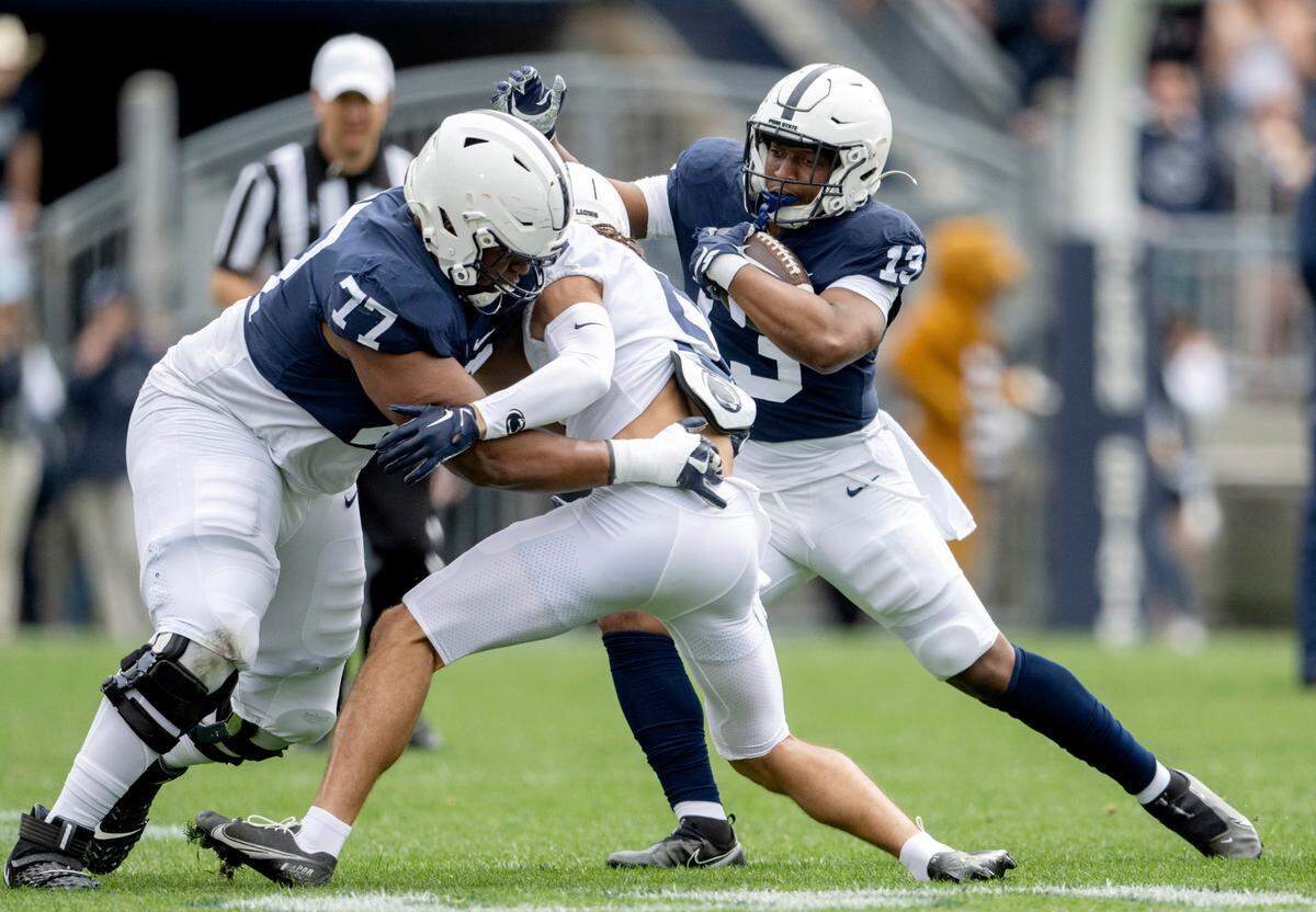 Running back Kaytron Allen just around offensive lineman Sal Wormley as he blocks cornerback Cam Miller during the Penn State Blue-White game on Saturday, April 15, 2023.