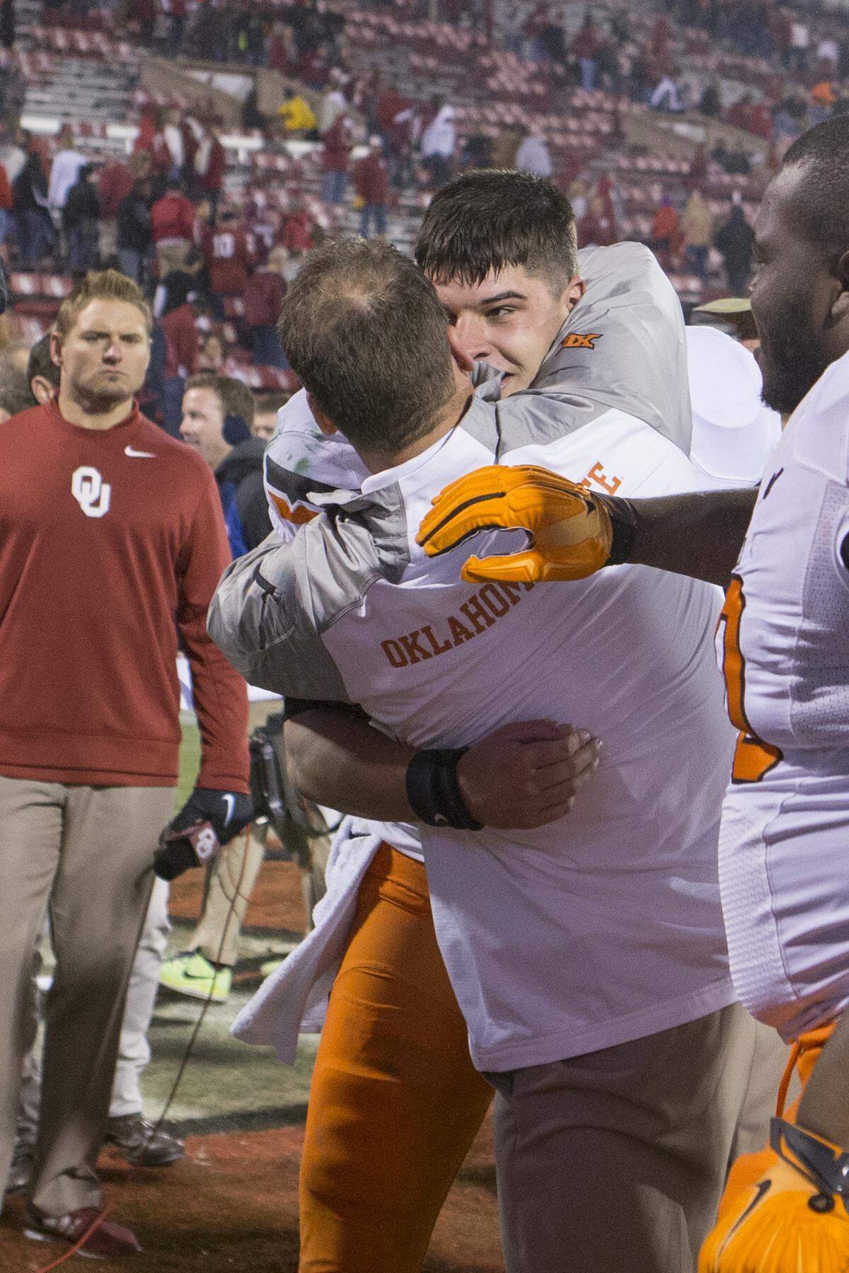 Mike Yurcich and Mason Rudolph embrace each other during the Oklahoma State Cowboys’ game vs. the Oklahoma Sooners on Saturday, December 6, 2014 at Oklahoma Memorial Stadium in Norman, Oklahoma.