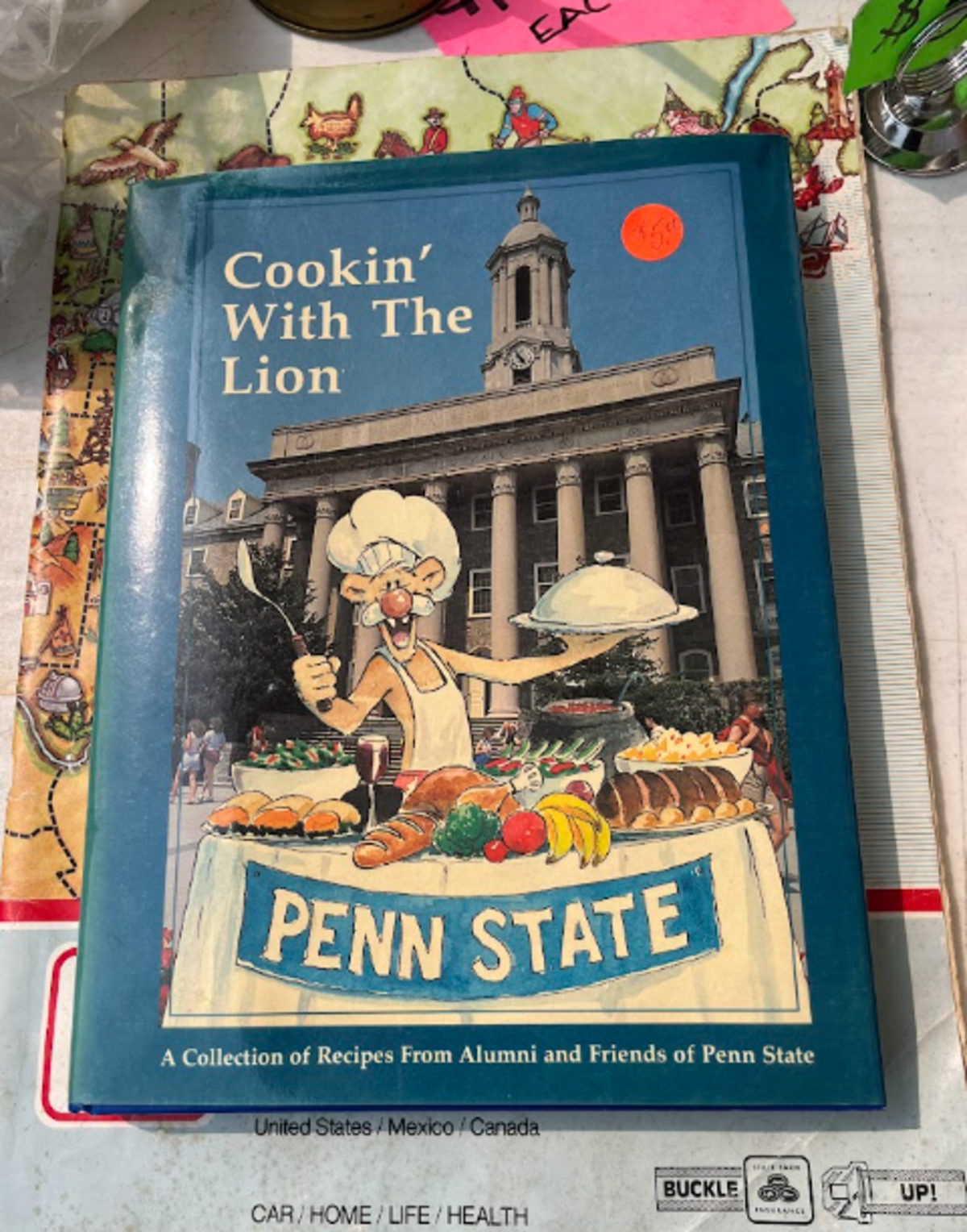 A “Cookin’ With The Lion” cookbook for sale in Pine Glen during the 100 Mile Yard Sale on Friday, July 17, 2026.
