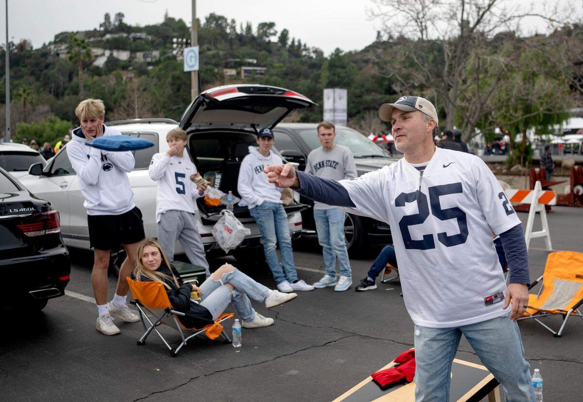 Yancy Unger plays a round of corn hole as he and he family and friends tailgate for the Rose Bowl on Monday, Jan. 2, 2023.