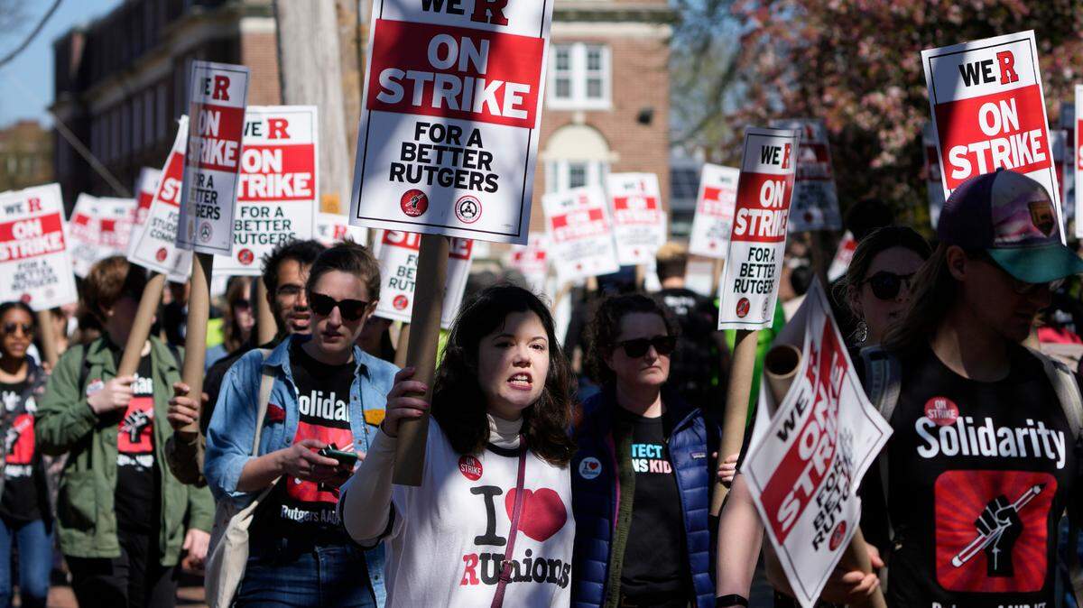 Strikers march in front of Rutgers’ buildings in New Brunswick, N.J., Monday, April 10, 2023. Thousands of professors, part-time lecturers and graduate student workers at New Jersey’s flagship university have gone on strike — the first such job action in the school’s 257-year history. (AP Photo/Seth Wenig)