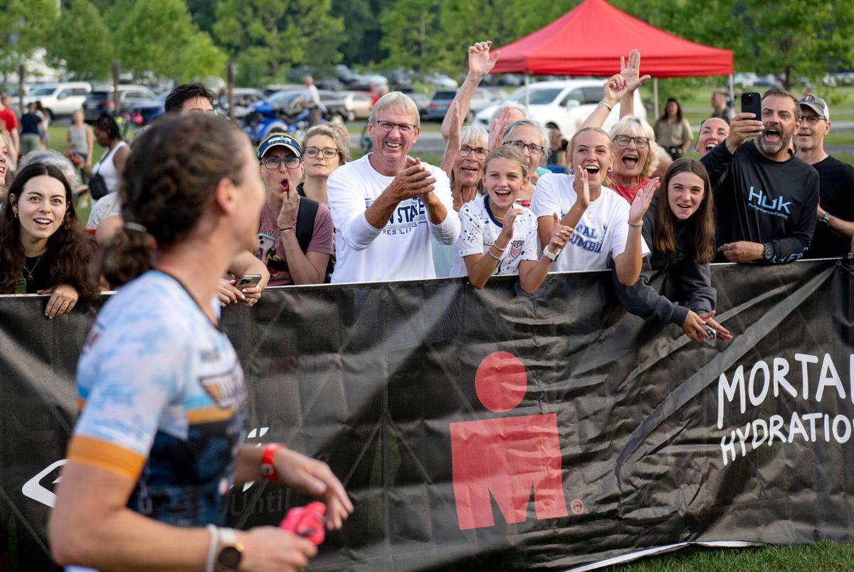 An athlete is cheered on as she leaves the water from the 1.2 mile swim in the Ironman 70.3 Pennsylvania Happy Valley on Sunday, June 30, 2024.